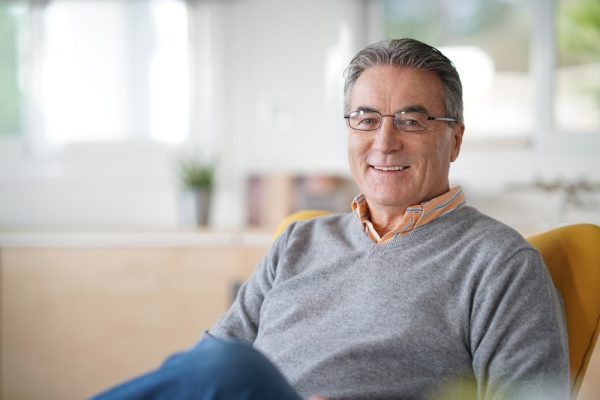 Smiling,Senior,Man,With,Eyeglasses,Relaxing,In,Armchair